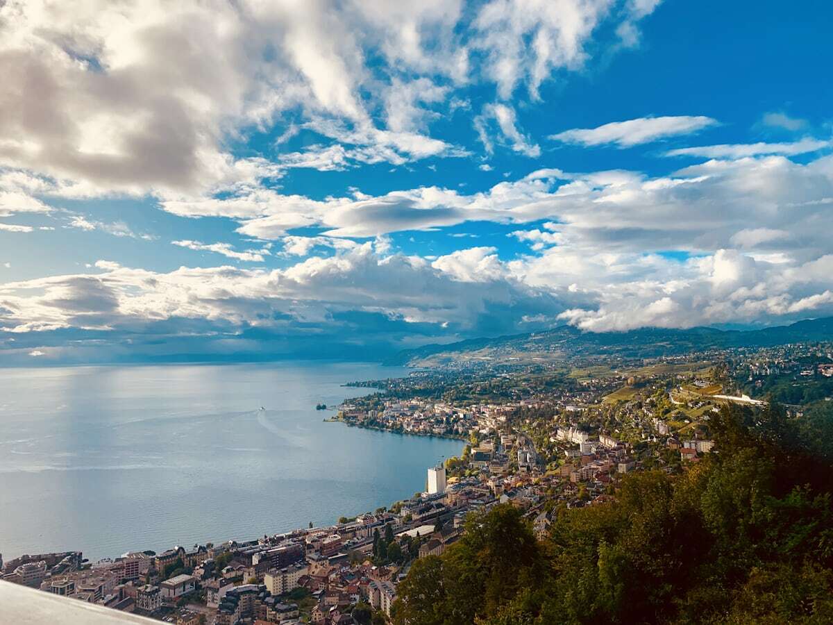 Palm-lined Montreux promenade on Lake Geneva with Alps beyond