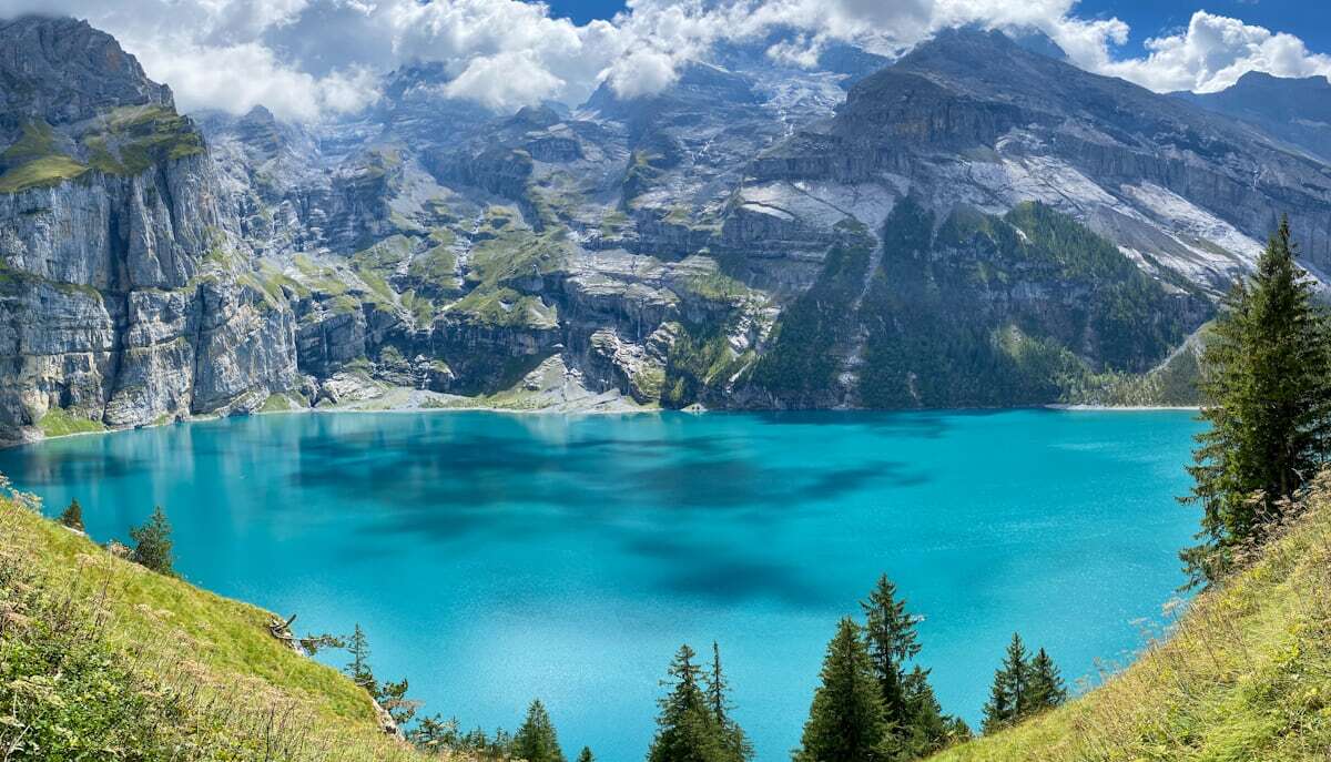 Turquoise Oeschinensee lake ringed by steep snow-streaked peaks