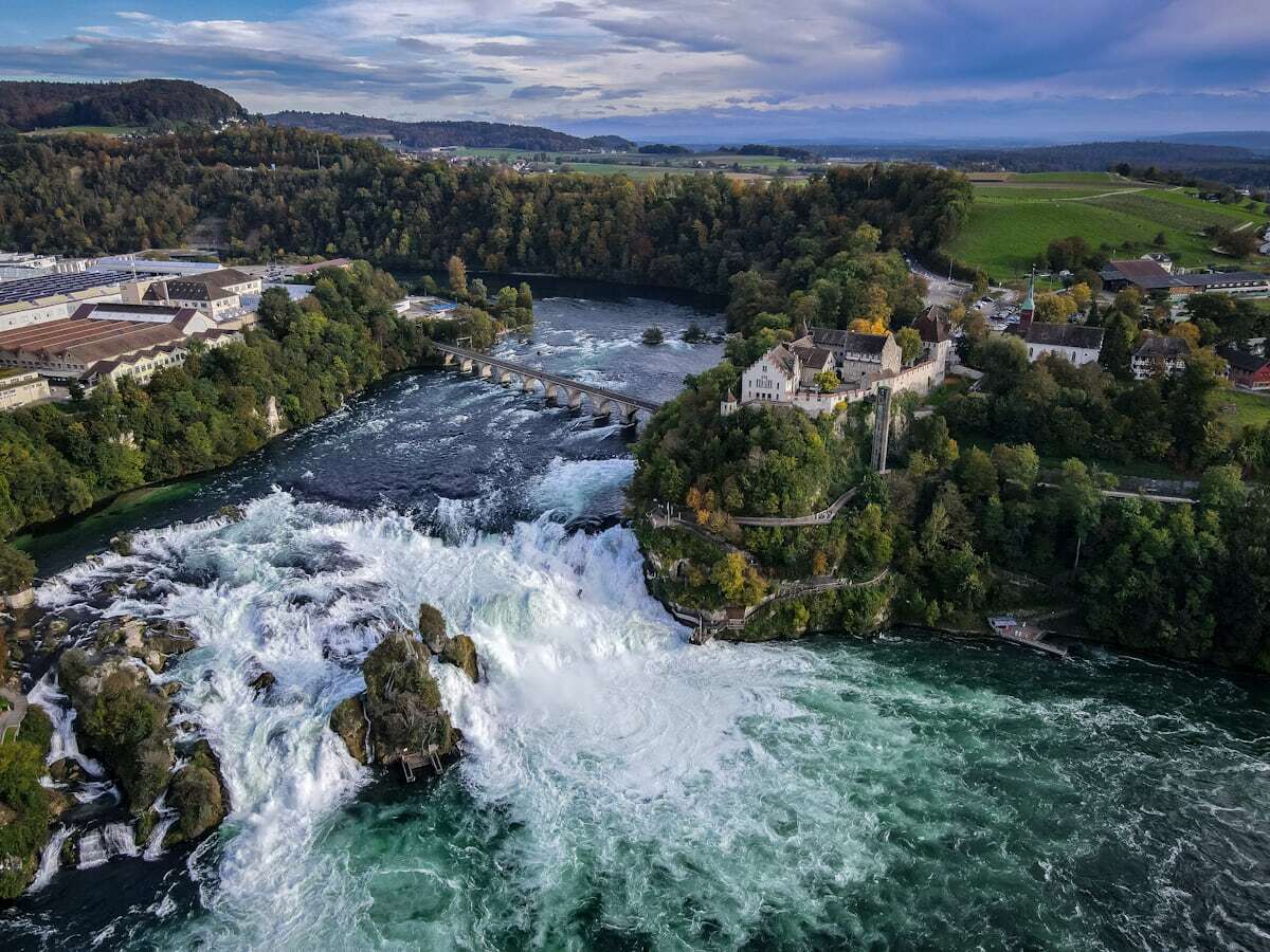 The wide, powerful Rhine Falls with a rock outcrop mid-cascade