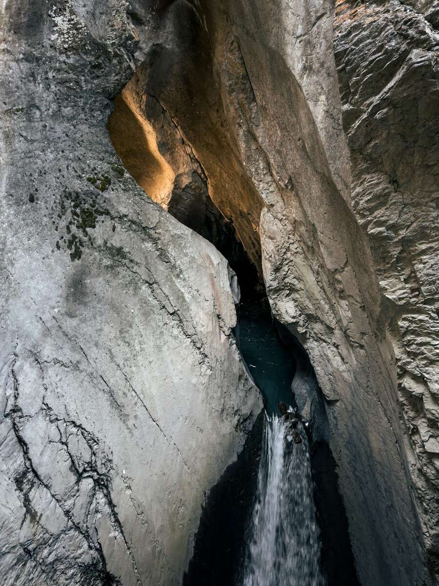 Glacial waterfall roaring through a rock gorge inside the mountain